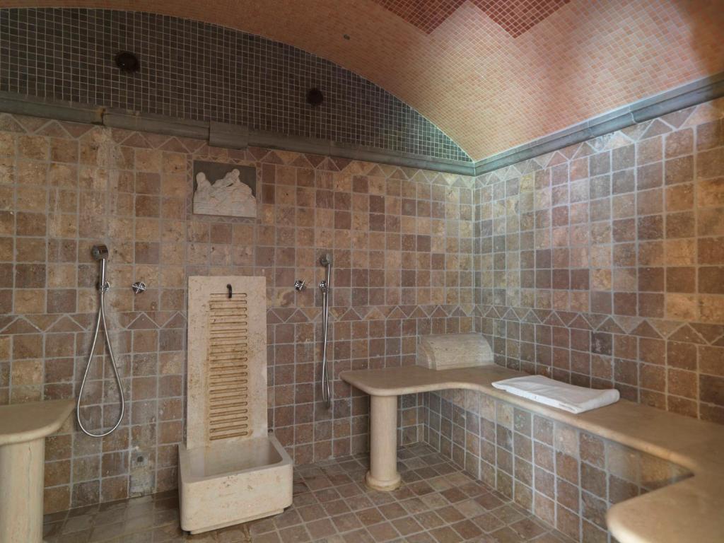 une salle de bain carrelée avec douche et lavabo dans l'établissement Montebelli Agriturismo & Country Hotel, à Caldana