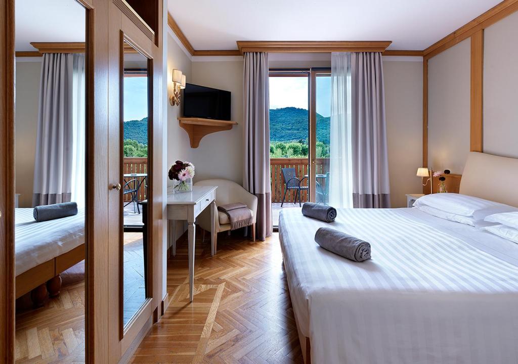 une chambre d'hôtel avec un lit, un bureau et une fenêtre dans l'établissement Iseo Lago Hotel, à Iseo