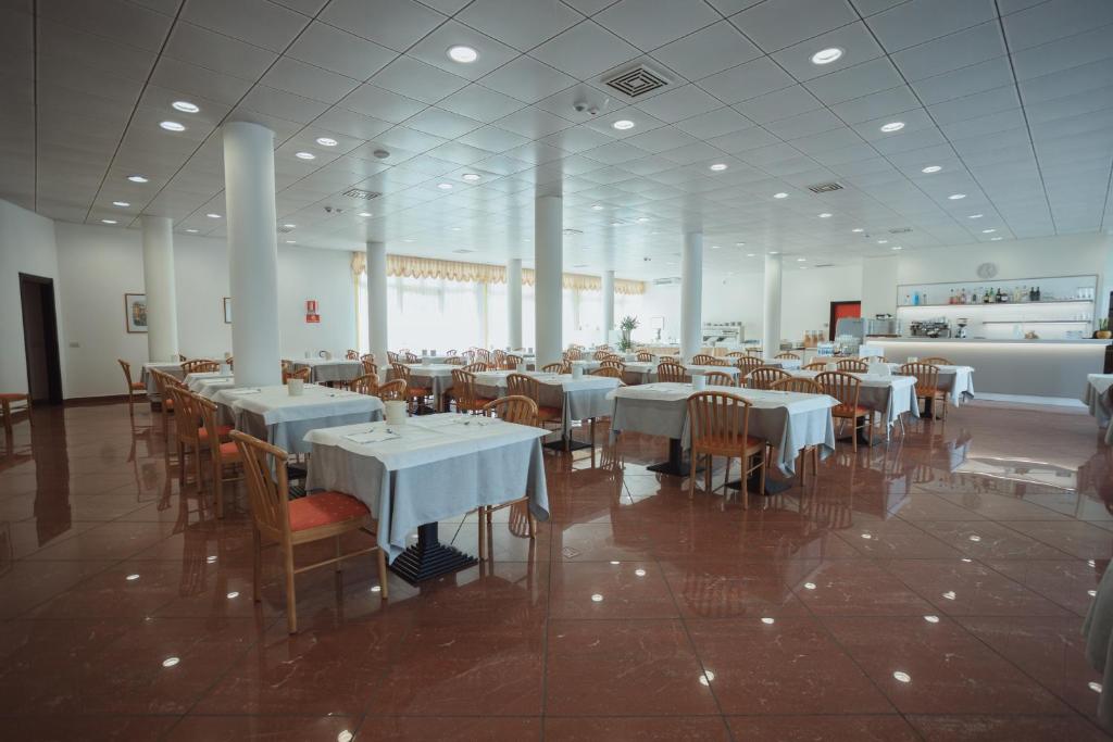 une salle à manger avec des tables et des chaises dans un restaurant dans l'établissement Hotel Santo Stefano, à Bibione 12 autres photos