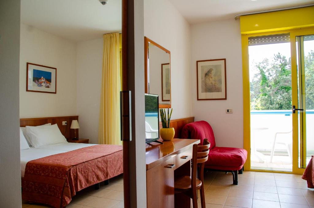 une chambre d'hôtel avec un lit, un bureau et une fenêtre dans l'établissement Hotel Santo Stefano, à Bibione