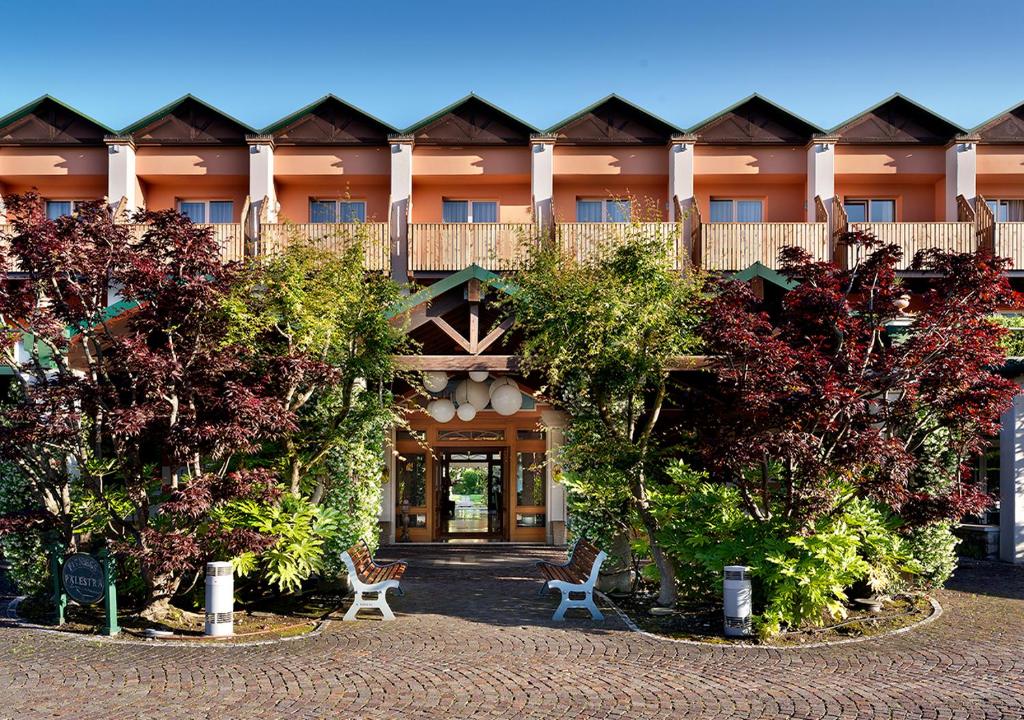 un grand bâtiment avec des arbres devant dans l'établissement Iseo Lago Hotel, à Iseo