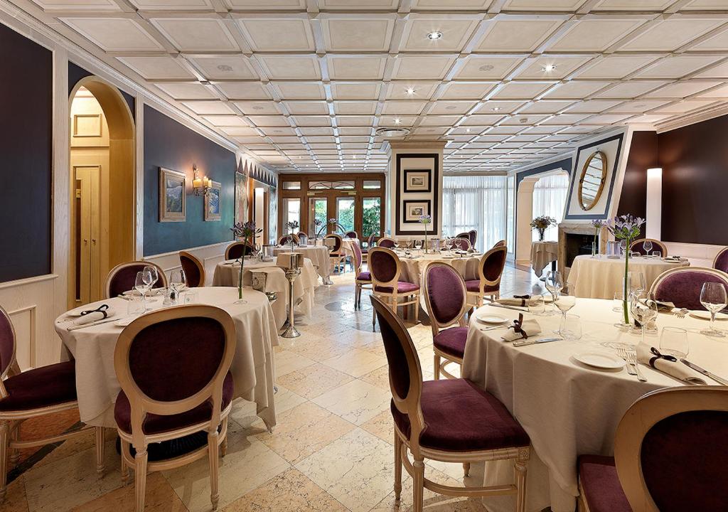 une salle à manger avec tables et chaises et tablesearcher dans l'établissement Iseo Lago Hotel, à Iseo