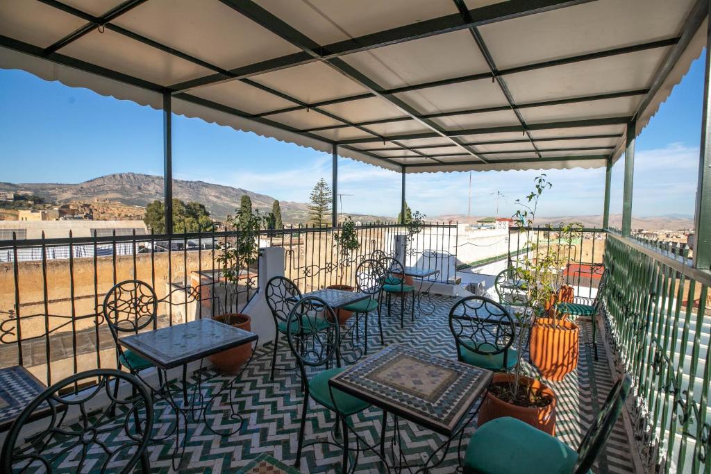 d'une terrasse avec des tables et des chaises et une vue sur un champ. dans l'établissement Riad Yamna Fez, à Fès