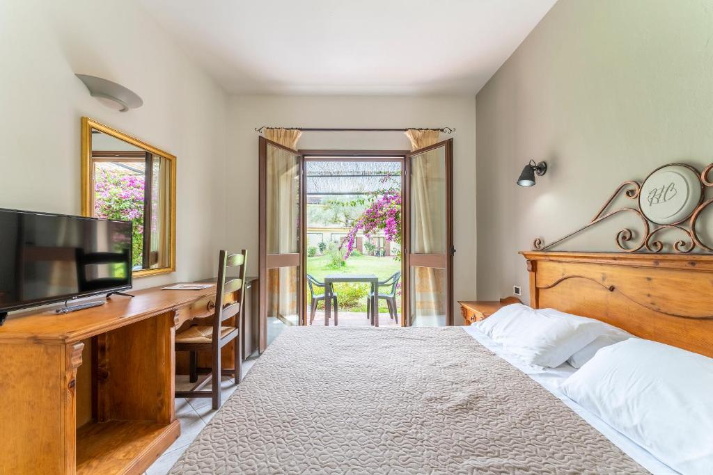 une chambre avec un lit, un bureau et une télévision dans l'établissement Horse Country Resort Congress & Spa - Hotel Ribot, à Arborea