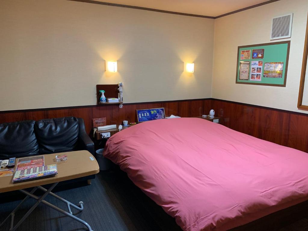 une chambre avec un lit et une table et une table sidx sidx sidx dans l'établissement ホテル あぱっち, à Tuyama