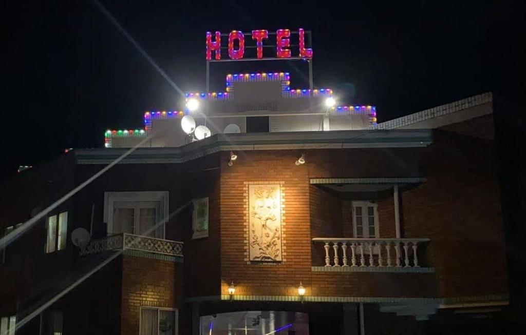 Un bâtiment avec un panneau de néon en haut. dans l'établissement ホテル オアシス, à Fukaya