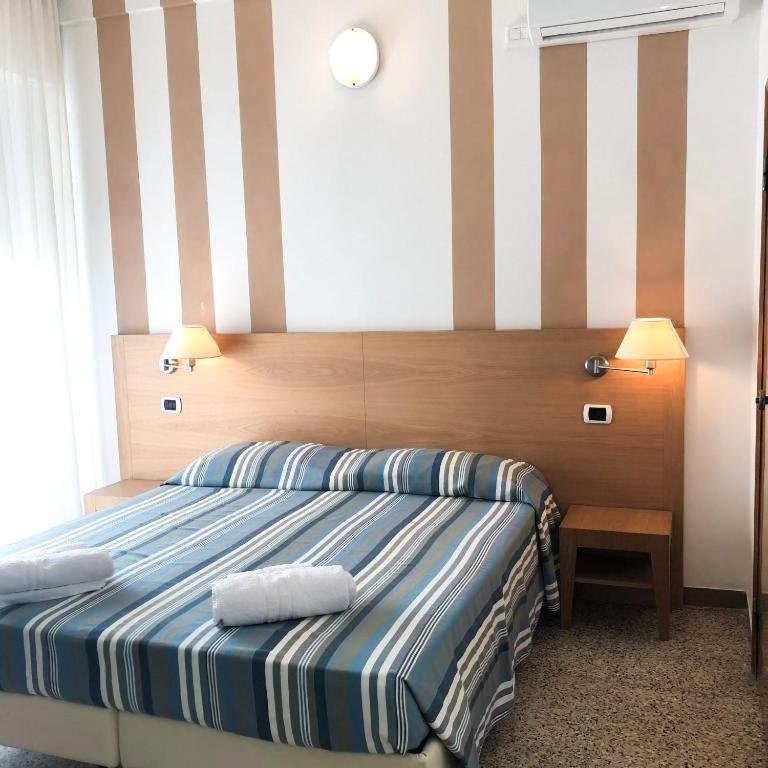 une chambre avec un lit avec deux serviettes dessus dans l'établissement Hotel Gin sul mare, à Rimini