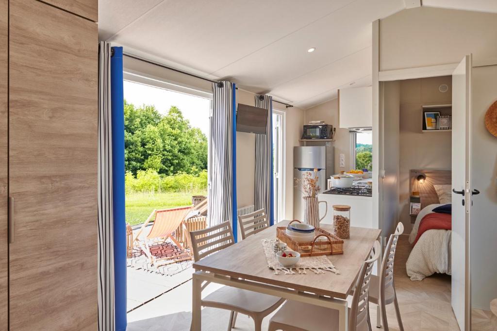 une cuisine et une salle à manger avec une table et des chaises dans l'établissement Camping l'Ile aux Oiseaux, à LʼÎle-dʼOlonne