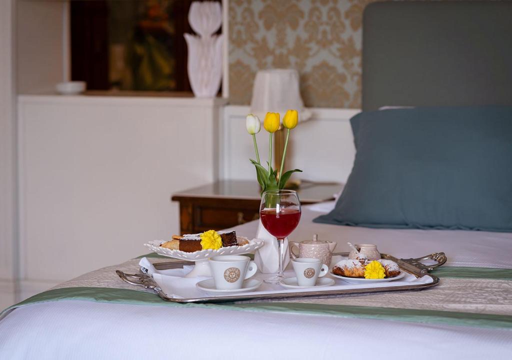 - un plateau de nourriture et un verre de vin sur le lit dans l'établissement Hotel Meridiana, à Paestum