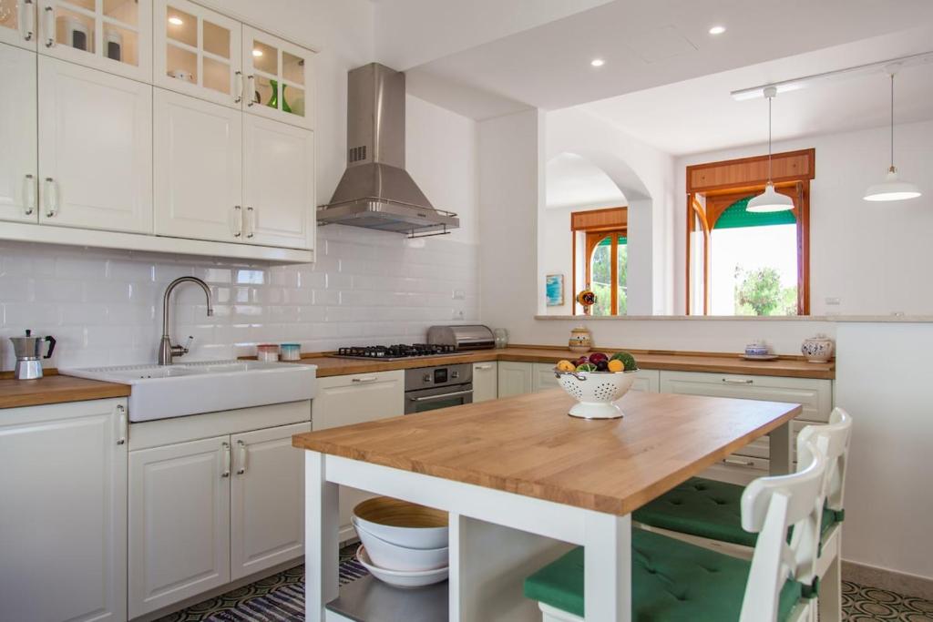 - une cuisine avec une table en bois et un bol de fruits dans l'établissement Villa Loreta LUXURY TOP FLOOR, à Gagliano del Capo