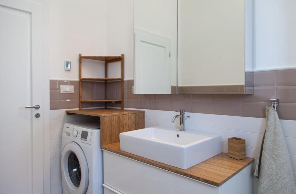 une salle de bain avec un lavabo et une machine à laver dans l'établissement Villa Loreta LUXURY TOP FLOOR, à Gagliano del Capo