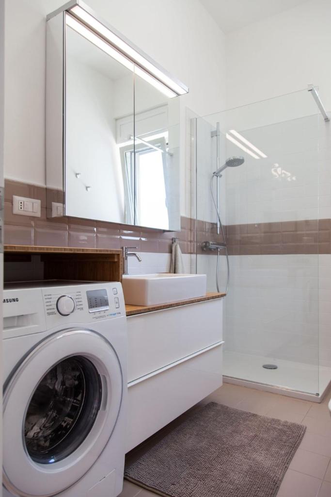 une salle de bain avec une machine à laver et un lavabo dans l'établissement Villa Loreta LUXURY TOP FLOOR, à Gagliano del Capo 37 autres photos