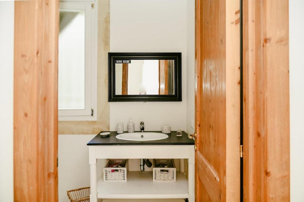 une salle de bain avec un lavabo et un miroir dans l'établissement Masseria Sant'Andrea, à SantʼAndrea