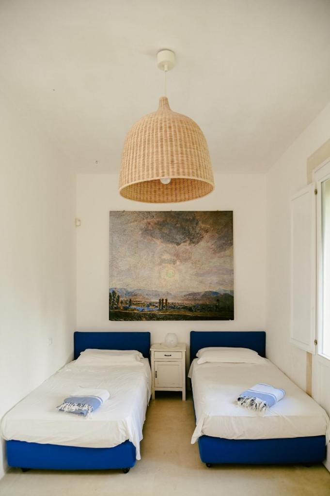 deux lits dans une chambre avec un tableau au mur dans l'établissement Masseria Sant'Andrea, à SantʼAndrea 100 autres photos