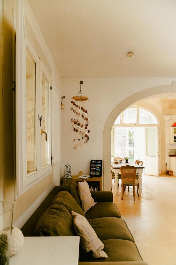 un salon avec un canapé vert et une table dans l'établissement Masseria Sant'Andrea, à SantʼAndrea
