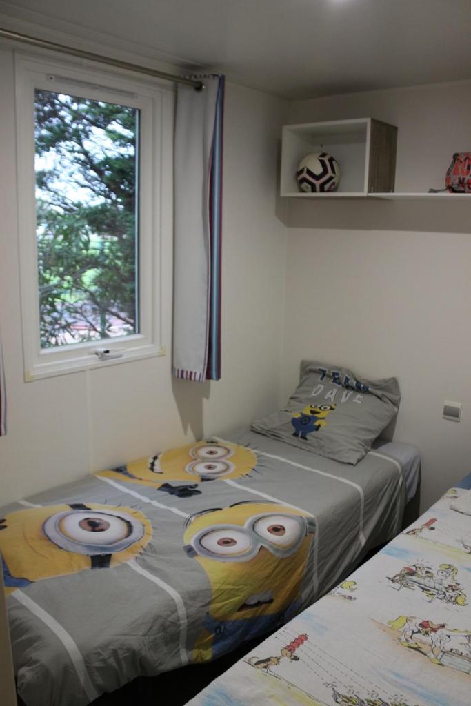 - une chambre avec 2 lits avec des yeux dans l'établissement Mobile Home 6 personnes climatisé, à Port-la-Nouvelle