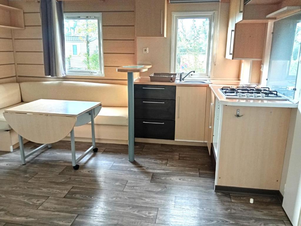 une cuisine avec une cuisinière et une table à l'intérieur dans l'établissement Mobil-Home Provence, à Cheval-Blanc