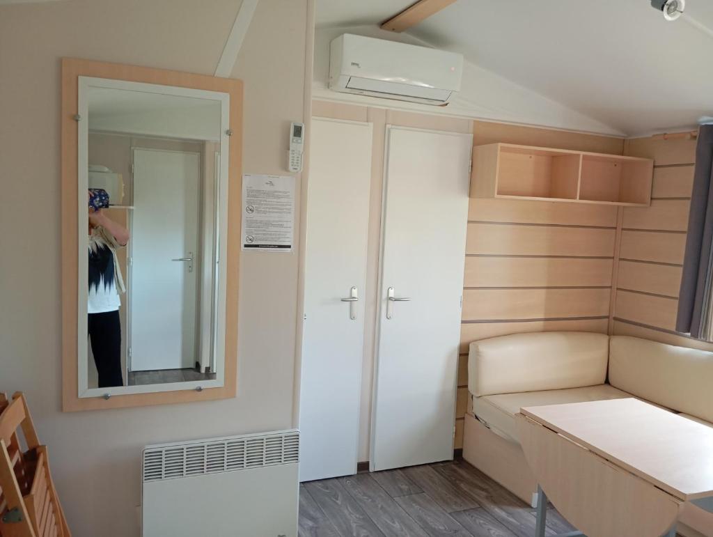 une petite chambre avec un lit et un miroir dans l'établissement Mobil-Home Provence, à Cheval-Blanc