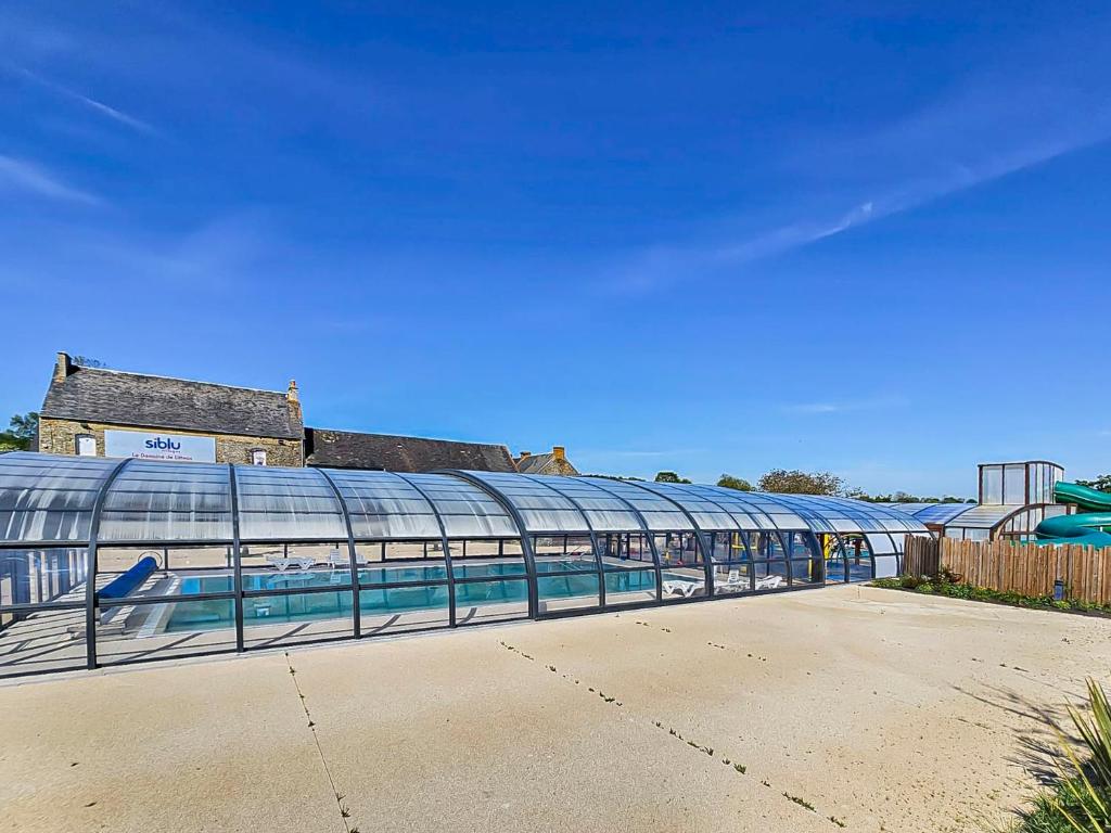 un bâtiment en verre avec une piscine. dans l'établissement Carpe Diem, à Litteau