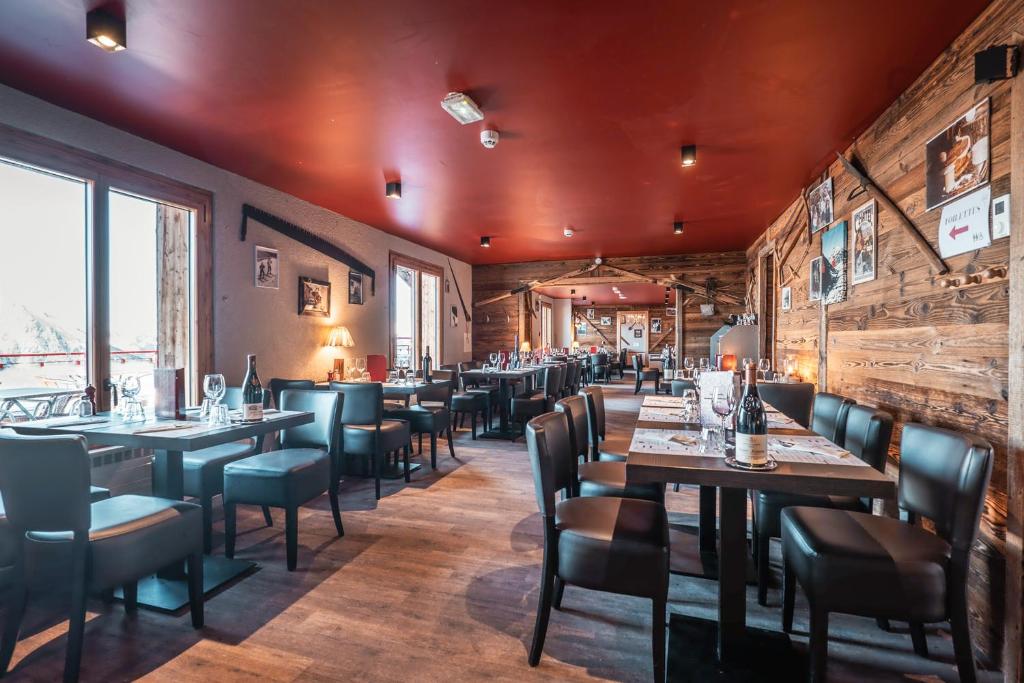un restaurant avec des murs en bois, des tables et des chaises dans l'établissement L'Escale (accès en télécabine), à Châtel