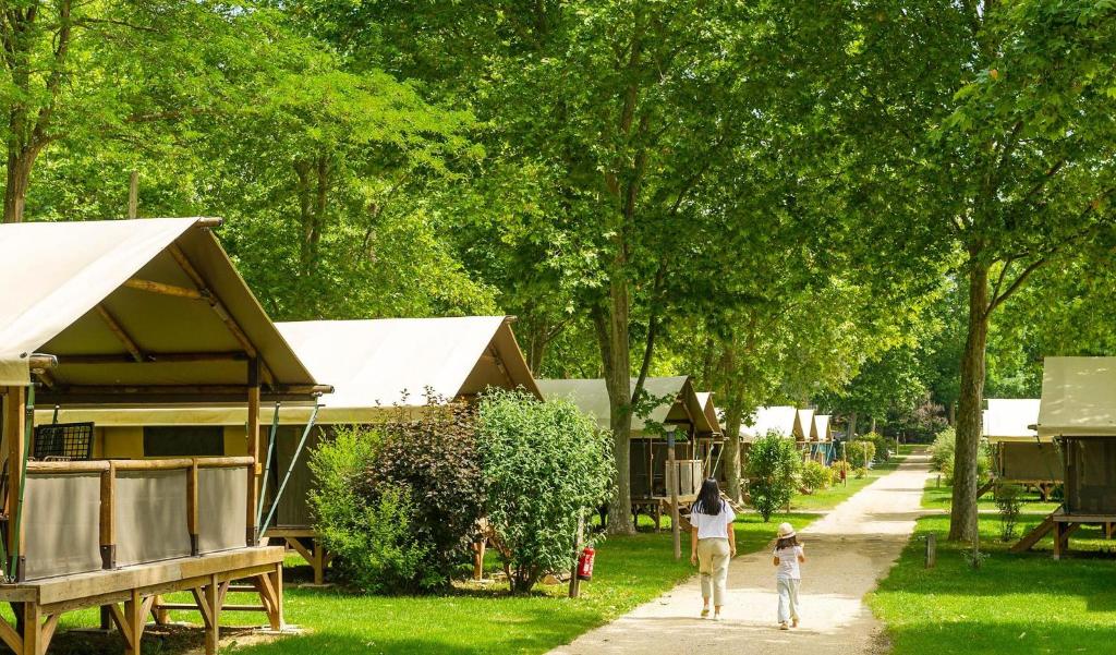 une femme et un enfant marchant sur le trottoir dans l'établissement Camping Château de Galaure, à Châteauneuf-de-Galaure