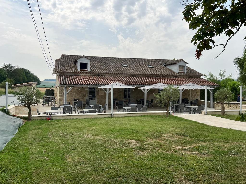 une maison dotée d'un toit avec des tables et des chaises dans l'établissement Chalet en camping, à Lévignac-de-Guyenne