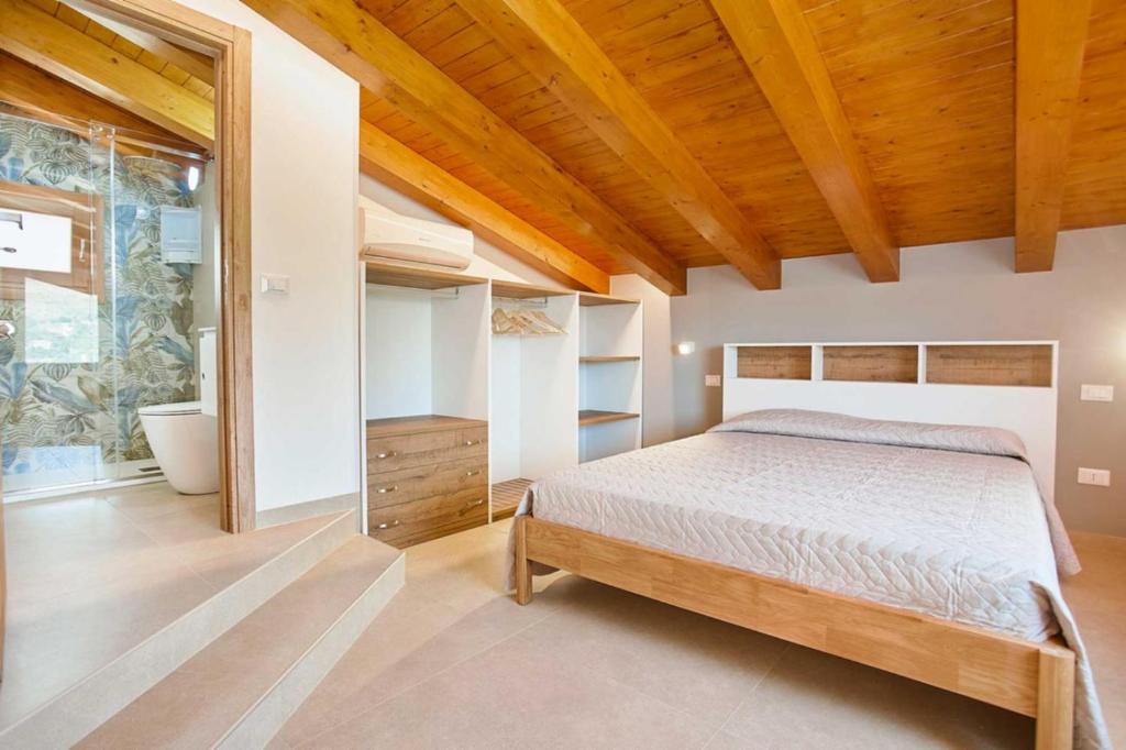 une chambre avec un lit et un plafond en bois dans l'établissement Villa Ninfa, à Castellammare del Golfo