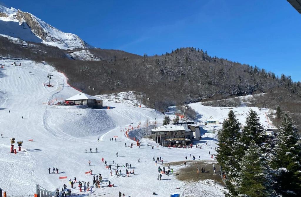 un groupe de personnes skier sur une piste de ski dans l'établissement Le Skidoux 2*, au pied des pistes, vue montagne, à Gourette
