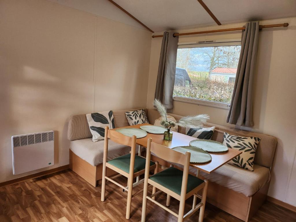 un salon avec une table et un canapé dans l'établissement Mobilhome les pieds dans l eau avec piscine, à Saint-Gérons