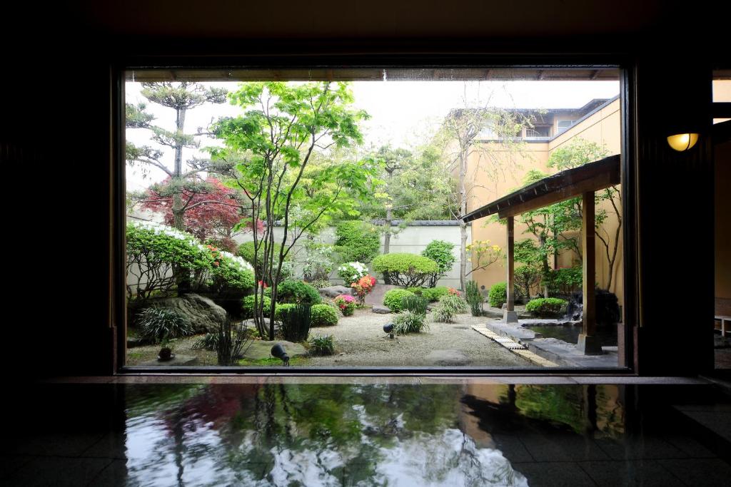 Elle offre une vue sur un jardin avec des arbres et des buissons. dans l'établissement Tabist Chikuba Shinyotei Hakodate Yunokawaonsen, à Hakodate