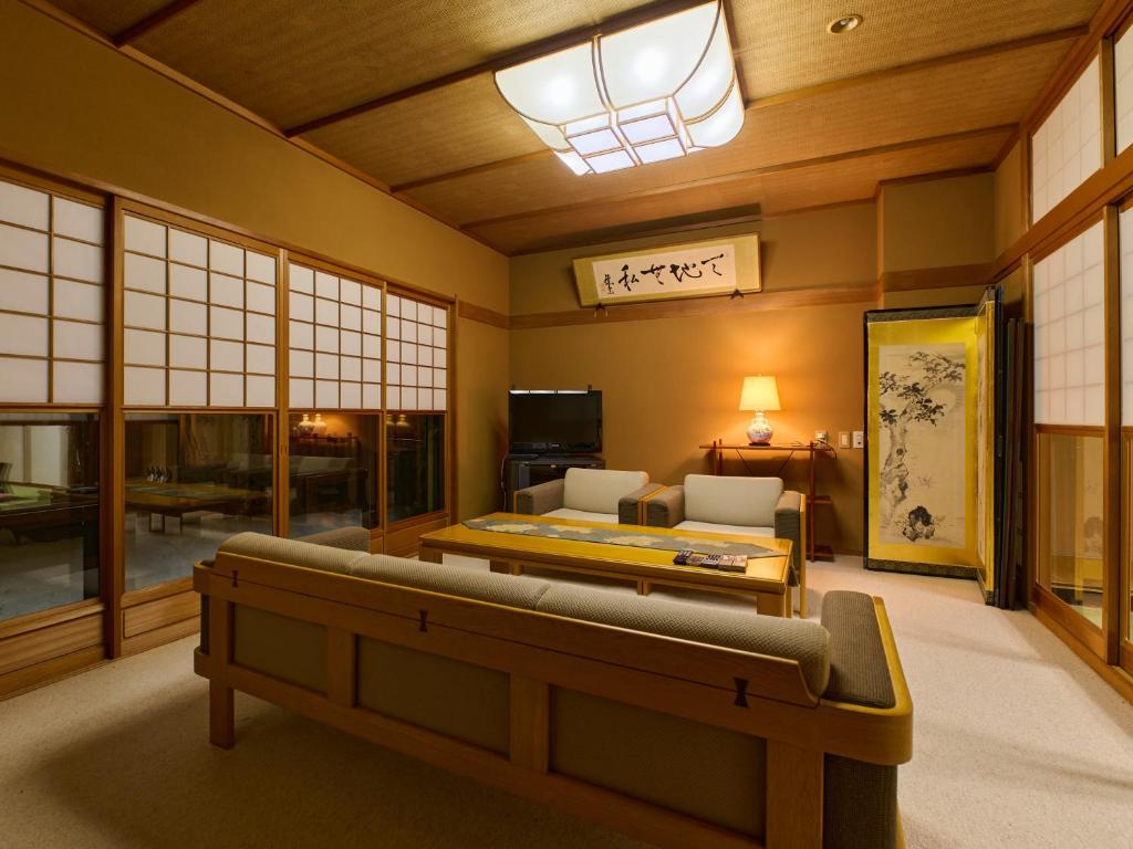 un salon avec un canapé et une table dans l'établissement Tabist Chikuba Shinyotei Hakodate Yunokawaonsen, à Hakodate
