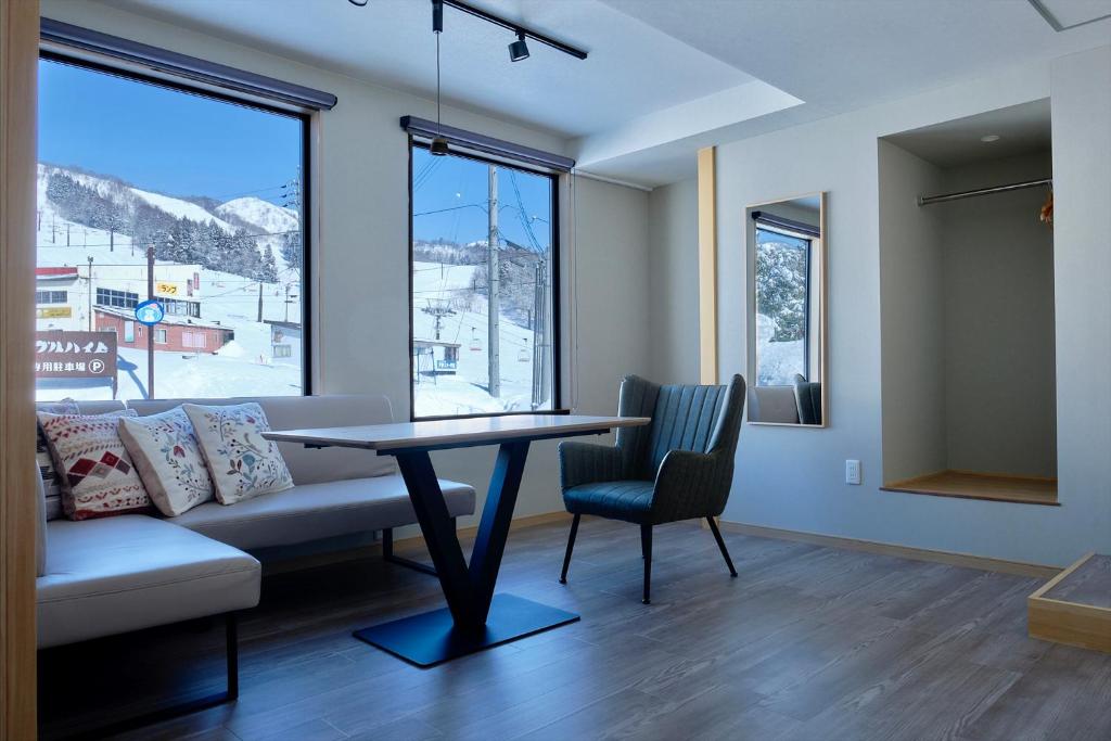 un salon avec une table et un canapé dans l'établissement メイプルハイム, à Iiyama