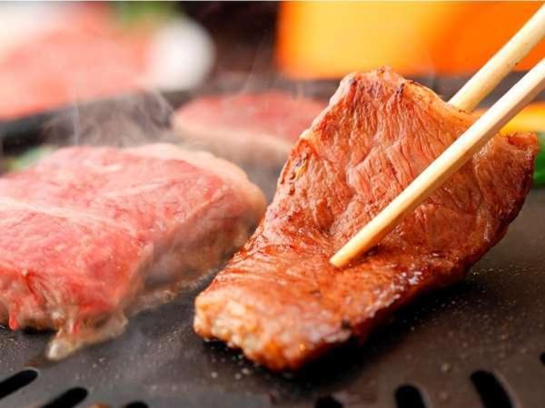 une fermeture de viande sur un grill avec des baguettes dans l'établissement Yumeoi-so, à Aso