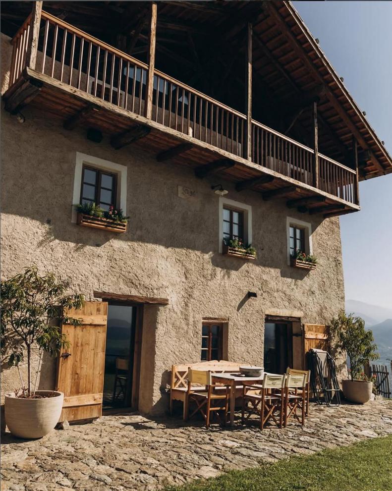 une maison avec une table et des chaises devant dans l'établissement Felder Alpin Lodge, à Villandro