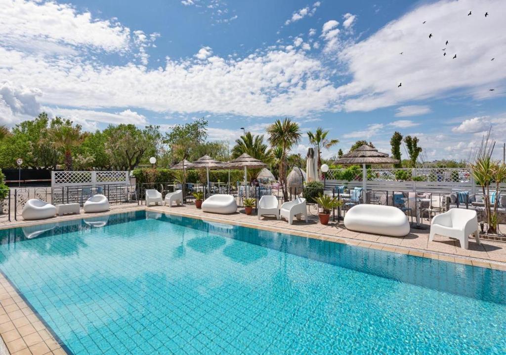 une grande piscine avec des chaises dans l'établissement Hotel Liberty Beach - Parking & Beach, à Riccione