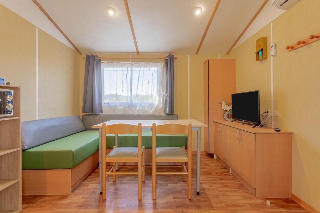 Cette chambre comprend un lit, deux chaises et une table. dans l'établissement Mobilhome Oasis village Puget, à Puget-sur Argens