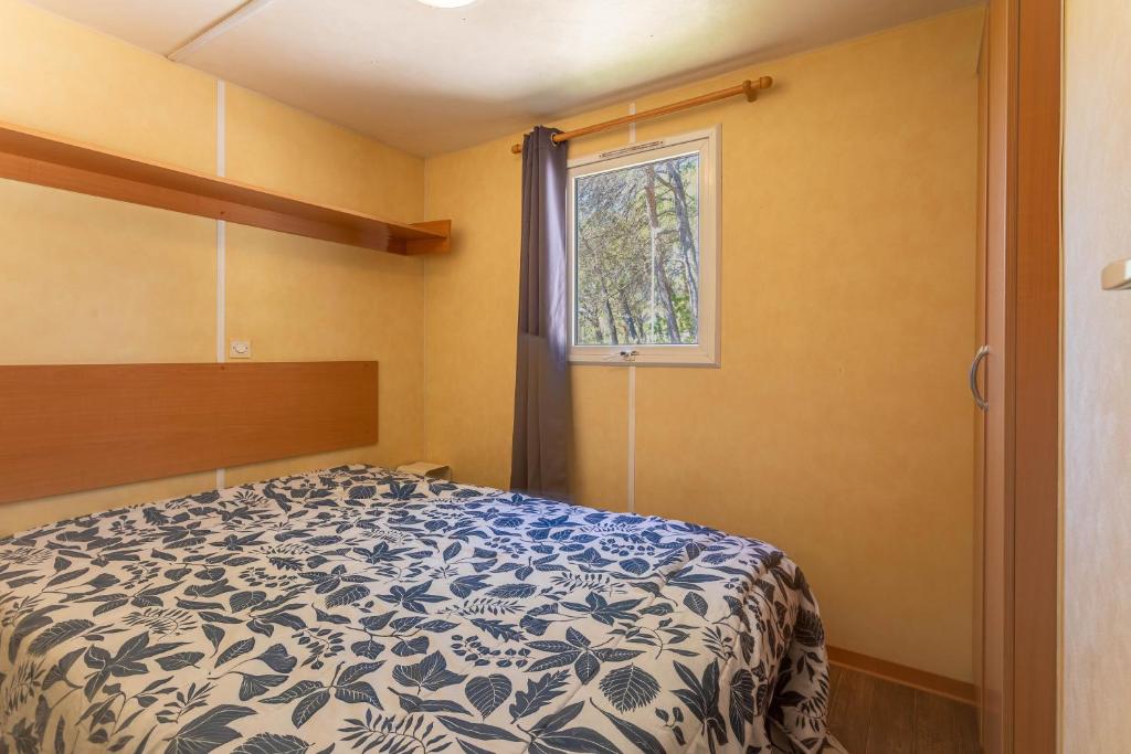 une chambre avec un lit et une fenêtre dans l'établissement Mobilhome Oasis village Puget, à Puget-sur Argens 19 autres photos