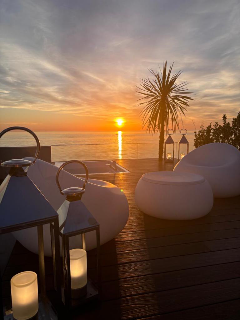 - un coucher de soleil sur l'océan avec bougies sur une terrasse dans l'établissement Hotel Sporting Riccione, à Riccione