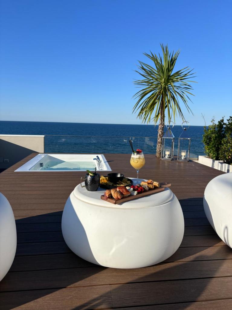 - une table avec de la nourriture et une boisson sur une terrasse dans l'établissement Hotel Sporting Riccione, à Riccione