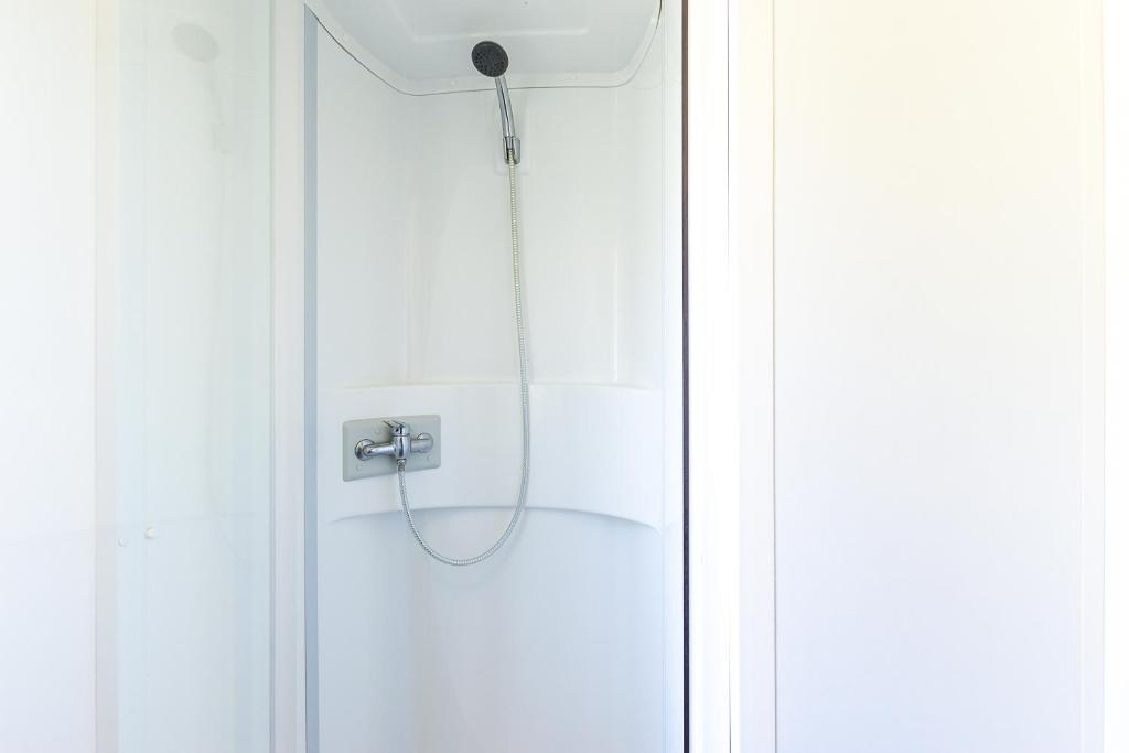 une douche avec un tuyau dans une porte blanche dans l'établissement Mobil home camping siblu, à Saint-Jean-de-Monts 15 autres photos