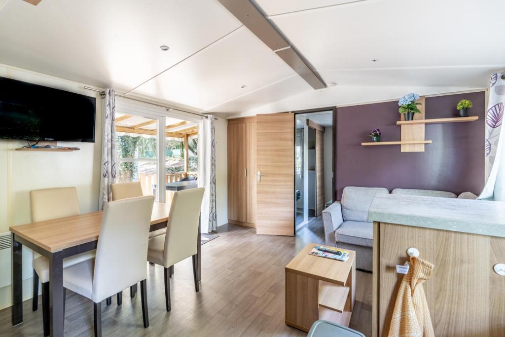 - un salon et une salle à manger avec une table et un canapé dans l'établissement Mobil home 8 personnes, à Saint-Brévin-les-Pins
