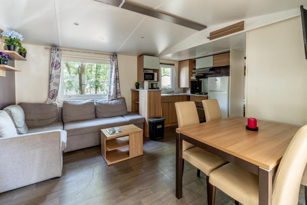 un salon avec un canapé et une table dans l'établissement Mobil home 8 personnes, à Saint-Brévin-les-Pins