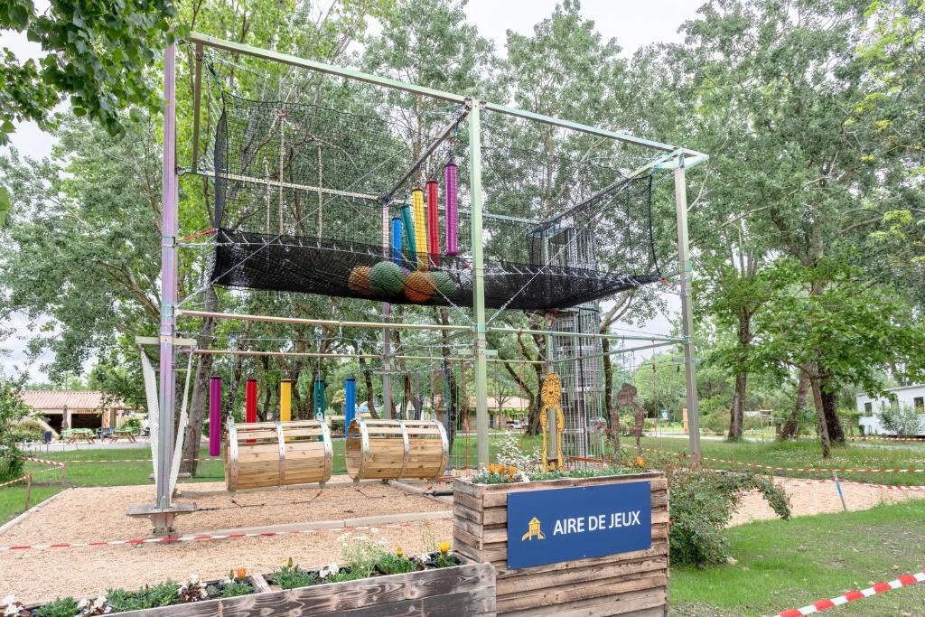 une cage à oiseaux avec des balles dedans dans un parc dans l'établissement Mobil-home, à Angles