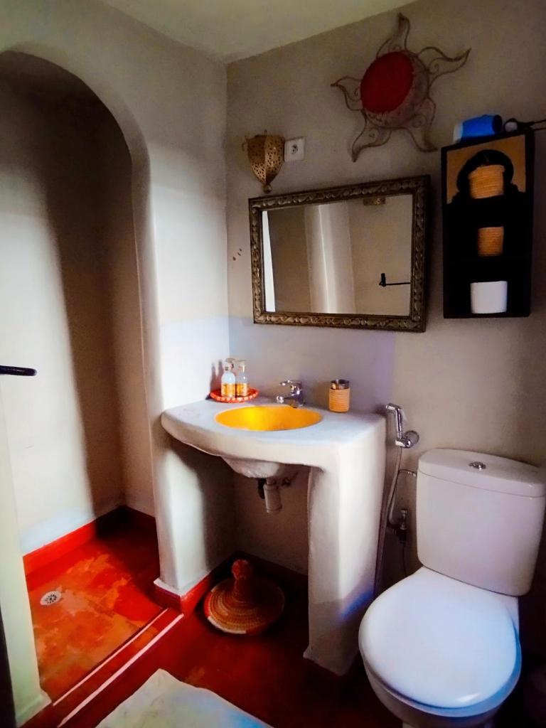 une salle de bain avec un lavabo blanc et des toilettes dans l'établissement riad cherif, à Marrakech