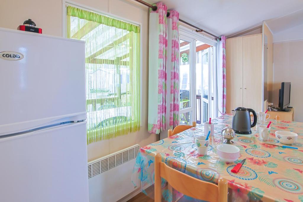 - une salle à manger avec une table et une nappe dans l'établissement Mobilhome tout équipé bois masson, à Saint-Jean-de-Monts