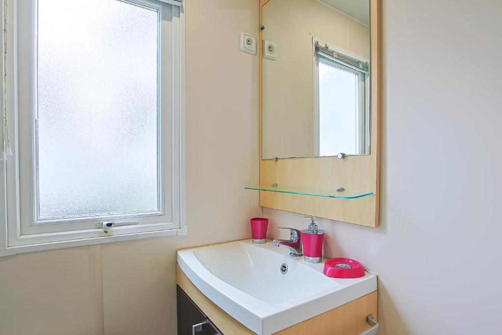 une salle de bain avec un lavabo et un miroir dans l'établissement Mobilhome tout équipé bois masson, à Saint-Jean-de-Monts 13 autres photos