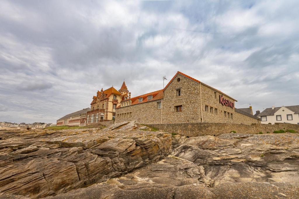 un grand bâtiment en briques au-dessus de rochers dans l'établissement Mobil-home - Quiberon - vue sur mer, à Quiberon
