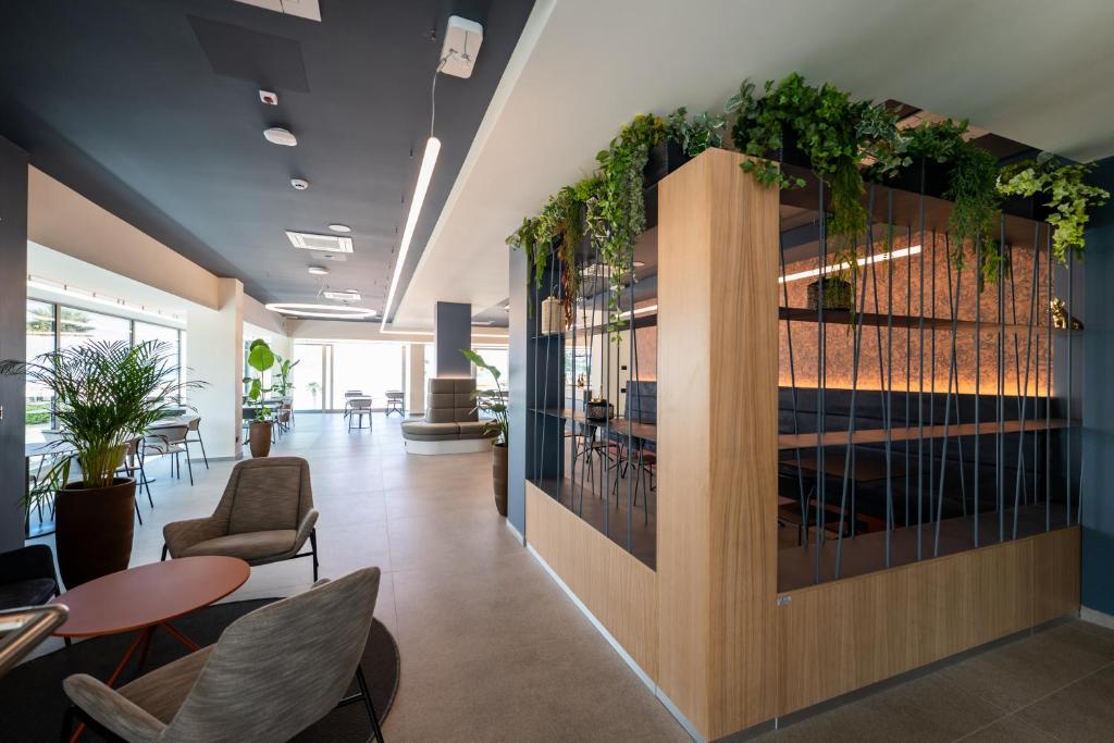 un hall d'immeuble de bureaux avec des plantes accrochées aux murs dans l'établissement Hotel Sporting Riccione, à Riccione