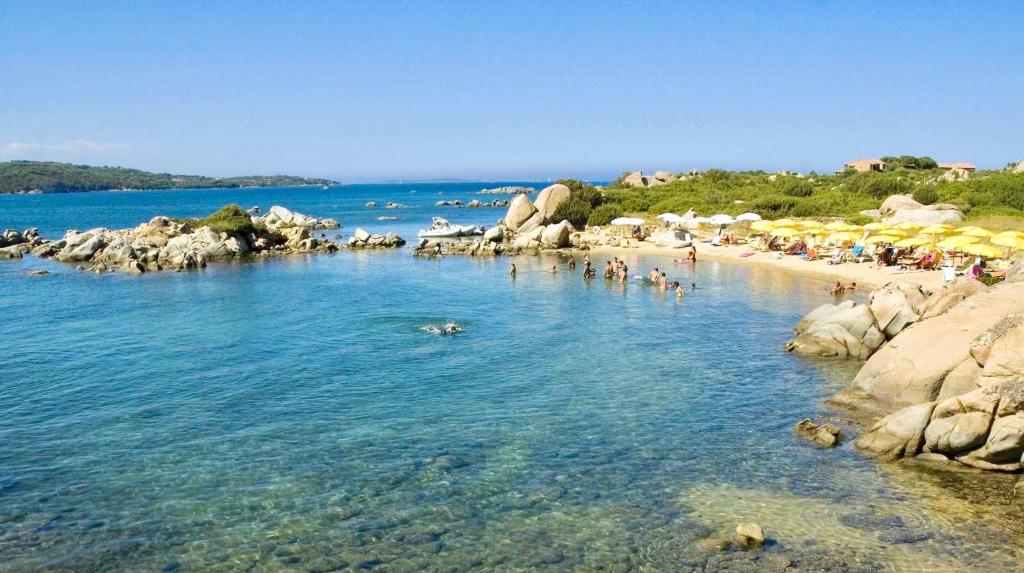 un groupe de personnes dans l'eau sur une plage dans l'établissement Residence with private beach in Marinella, à Marinella