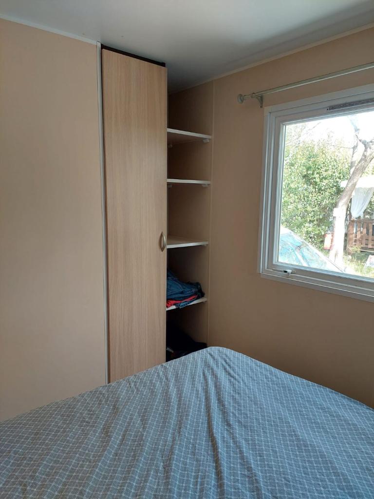 une chambre avec un lit et une fenêtre dans l'établissement Mobil-home - Le 147 aux Iscles, à La Roque-dʼAnthéron 11 autres photos